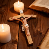 2-crucifix statue with inri on wooden table with candels