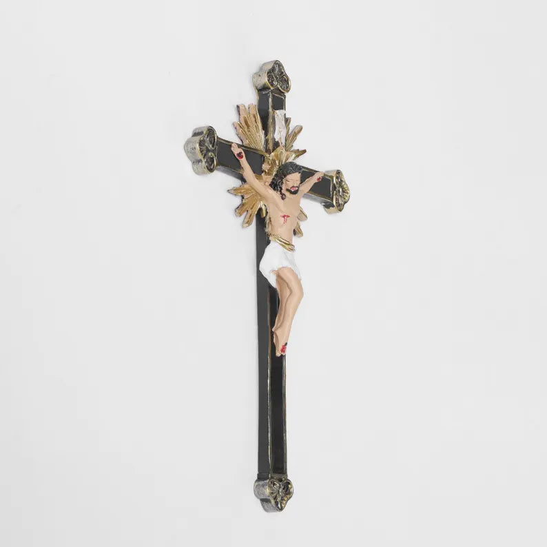 ornate black and gold wall crucifix statue plain background